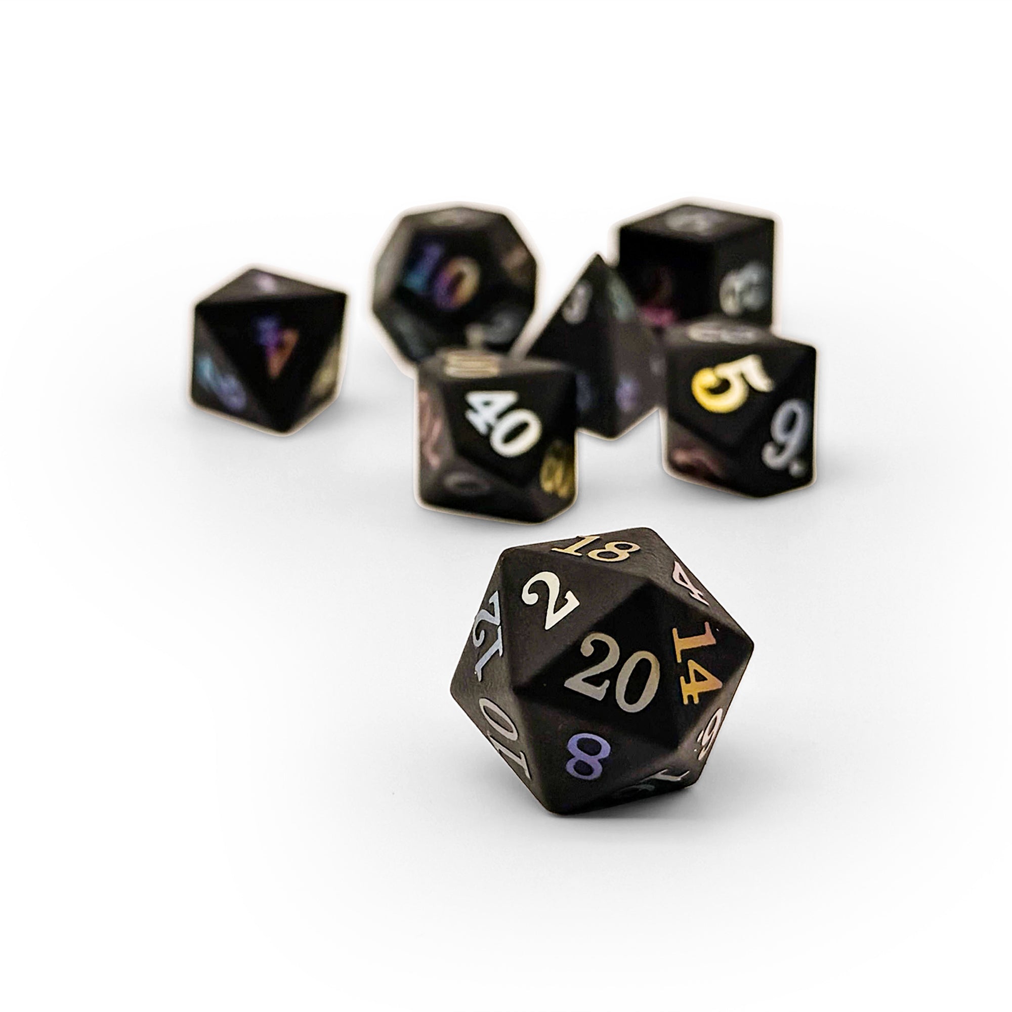 Set of black polyhedral dice with gold numbers on a white background